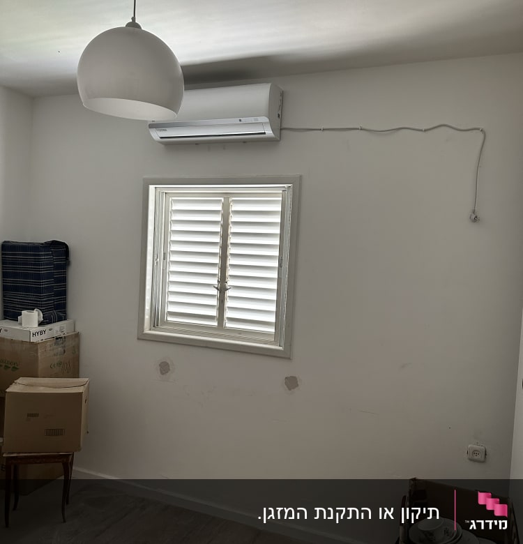 מזגן מותקן על קיר מעל חלון עם תריסים